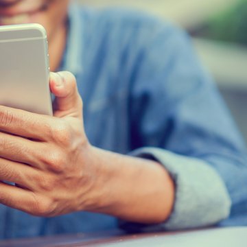 identity guard identity theft protection service mobile app man in blue shirt on smartphone